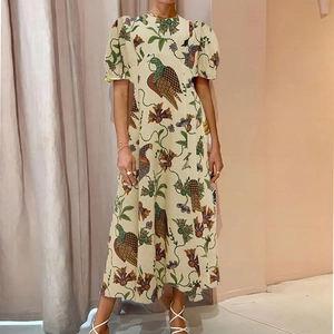 Détail de l'imprimé fleurs et oiseaux sur robe midi beige à manches courtes bouffantes
