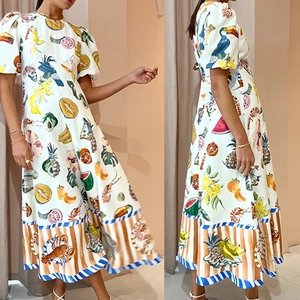 Détail de la robe midi blanche avec imprimés tropicaux et bordures rayées au bas