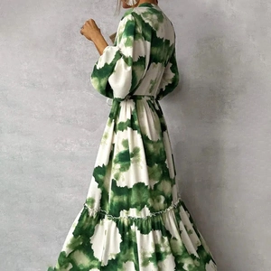 Detailed back view of green ink print dress with tiered skirt and waist tie belt