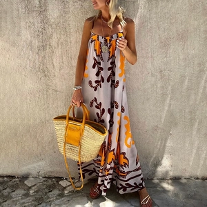 Detail shot of tropical print maxi dress with fine straps and vibrant orange patterns