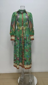 Détail des manches bouffantes avec imprimés oiseaux et fleurs sur robe longue verte