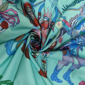 Dettaglio del tessuto verde menta con stampe floreali artistiche e finitura in raso lucido