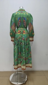 Détail de l'imprimé floral et oiseaux exotiques sur la robe plissée verte élégante