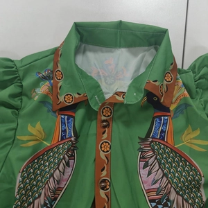 Détail de robe verte à imprimé paon avec manches plissées rétro et boutons vintage