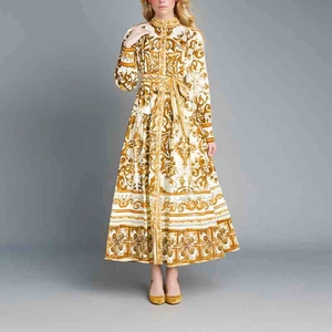 Vue détaillée de face d'une robe longue blanche avec motifs baroques dorés et ceinture