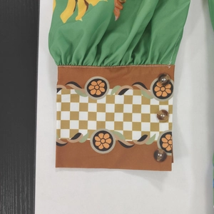 Détail du poignet bouffant avec imprimé fleuri et boutons décoratifs effet marbre