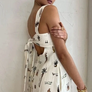 Détail de la robe fleurie blanche dos nu avec un grand nœud à nouer et une découpe chic