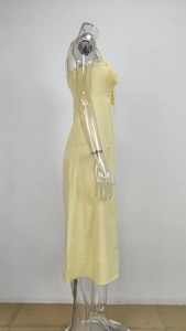 Detail view of light yellow satin midi dress with pleated bust and side slit on mannequin