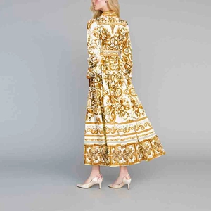 Détails de la robe longue blanche avec imprimé baroque doré et manches lanternes élégantes