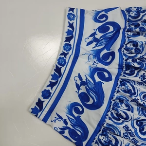 Detail of blue and white Mediterranean style floral print and pleated waist on a skirt