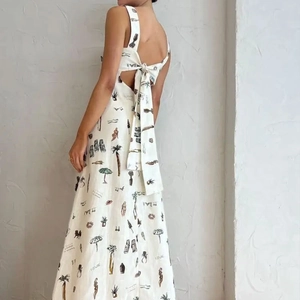 Détail de robe blanche dos nu avec un grand nœud papillon et imprimés de vacances