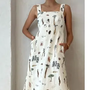 Détail d'une robe blanche sans manches avec imprimés tropicaux de palmiers et silhouettes