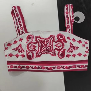 Detail view of a white cropped tank top featuring vibrant red vintage Majolica tile print