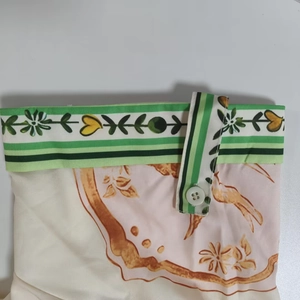 Dettaglio del tessuto a stampa floreale vintage con bordo a righe e bottone bianco