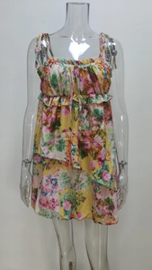 Detail of floral spaghetti strap dress showing yellow fabric and ruffle hem texture
