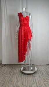 Détail de la robe rouge à une épaule avec motifs d'étoiles et ourlet volanté asymétrique