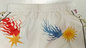 Detail of white printed shorts with elastic waistband and colorful sun patterns