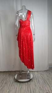 Détail de la robe rouge à une épaule avec motifs d'étoiles et coupe asymétrique fluide