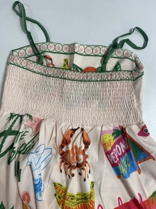 Detailed view of elastic smocked bodice and tropical print on a summer slip dress