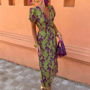 Detailed close-up of vibrant green floral dress featuring V-neck and puff sleeves