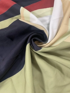 Detail of soft fabric with colorful abstract geometric prints and smooth drape texture