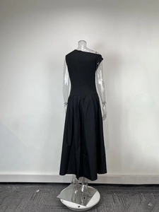 Détail d'une robe longue noire élégante à épaule dénudée avec taille haute et col asymétrique