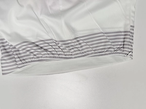 Detail of white fabric dress showing elastic band design and invisible zipper closure
