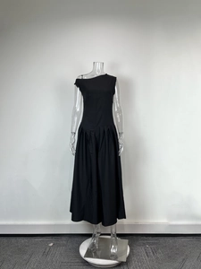 Détail d'une robe mi-longue noire élégante sans manches avec jupe plissée et col asymétrique