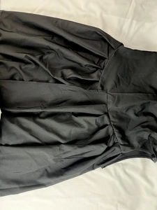 Gros plan sur la taille haute et l'ourlet plissé élégant d'une robe longue noire