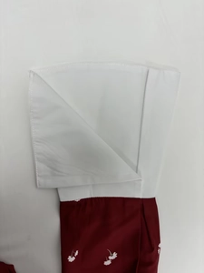 Vue détaillée de la manche contrastée élégante avec tissu blanc et motif floral rouge