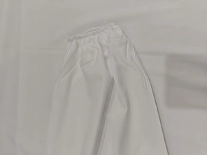 Detail of white high-waist elastic trousers in lightweight breathable cotton fabric