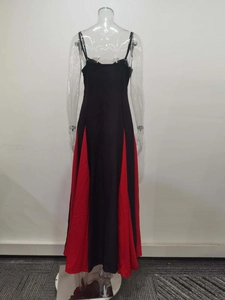Rear view of long black dress featuring red contrast triangular patchwork on large hemline