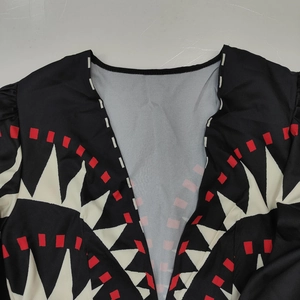 Détail du col en V avec imprimé géométrique et coutures fines sur robe vintage