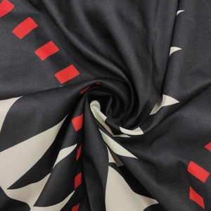 Gros plan détaillé d'un tissu à motifs géométriques noirs, blancs et rouges