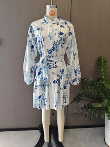 Detail view of high collar with cloth buttons and lantern sleeves on floral dress