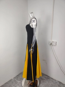 Detailed side view of backless black dress with yellow patchwork A-line skirt details