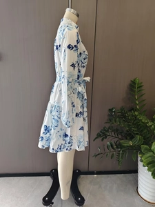 Detail view of long-sleeve dress with blue floral print and waist tie on mannequin