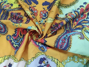 Detailed close-up showing silky paisley print fabric with vibrant yellow and blue patterns