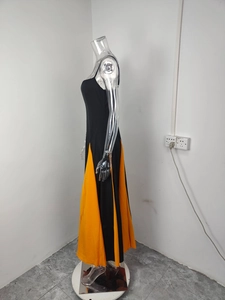Detail view of contrast color paneling on the black and orange A-line maxi dress