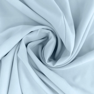 Détail du tissu de robe bleu clair avec texture maille fine et drapé élégant