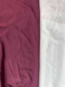 Détail de la texture macro d'un tissu soyeux bordeaux et blanc avec de légers reflets