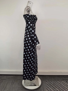 Detailansicht des gefalteten Ausschnitts und Retro-Punktemusters am figurbetonten Kleid