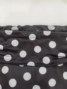 Detailansicht der elastischen Taille mit weißen Punkten auf schwarzem Stoff für das Kleid