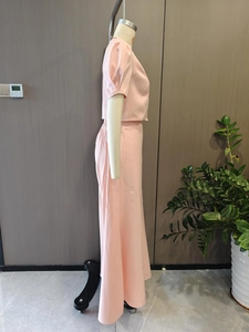 Vue latérale d'un ensemble deux pièces rose clair avec haut court et jupe longue taille haute