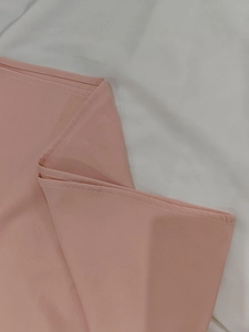 Détail du tissu en mousseline rose clair avec bordure à double couture plate pro