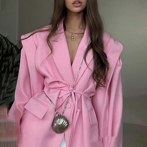 Detail of pink oversized blazer featuring structured shoulders and waist tie belt closure