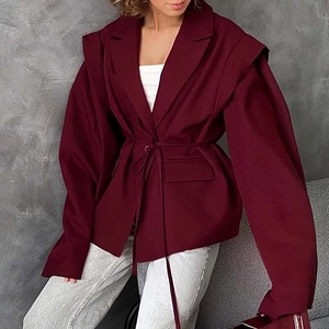 Detail of burgundy V-neck blazer showing textured fabric and structured waist tie