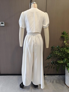 Détail du dos d'un haut court blanc à manches courtes et d'un pantalon large à taille haute