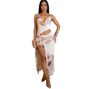 Detail of ruffle hem and sexy high slit on halter neck printed dress with metal ring