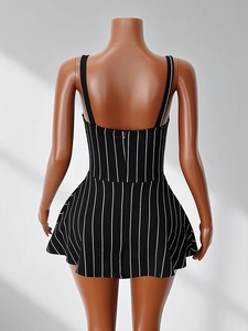Back view of a striped black and white sleeveless dress with a fitted waist and flared hem